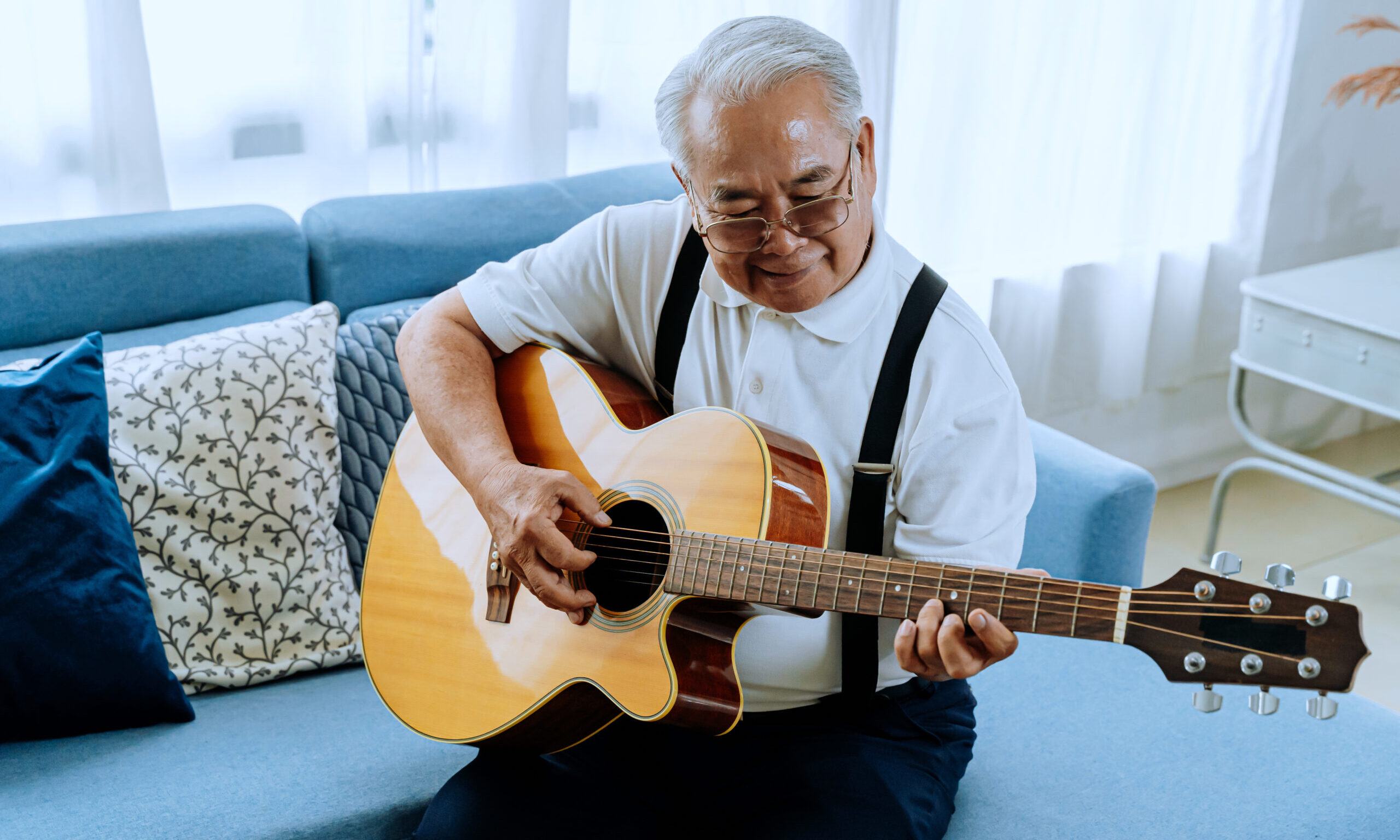 cropped-older-man-playing-guitar-on-blue-couch-scaled-1.jpg